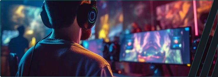 Um menino senta-se em frente a um monitor ligado e joga um jogo.
