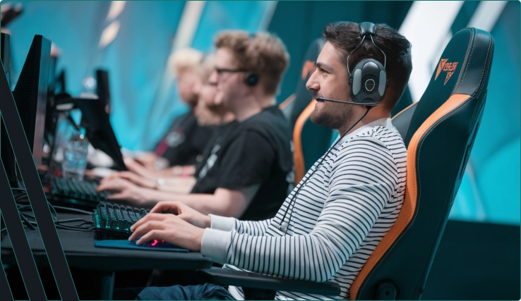 Dois jovens estão sentados em frente ao computador jogando um jogo.